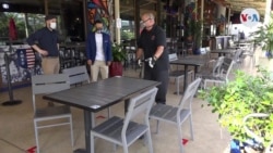 Operarios desinfectan un restaurante en la zona financiera de Miami antes de su reapertura tras la crisis del coronavirus