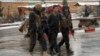 FILE - Afghan security personnel detain a suspect at the site of an attack on the Marshal Fahim military academy in Kabul, Afghanistan, Jan. 29, 2018. The Islamic State group claimed responsibility for the assault. 