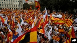 Ciudadanos agitan banderas de Cataluña y España mientras celebran un día de fiesta conocido como el "Día de la Hispanidad" en Barcelona, España, 12 de octubre de 2017.