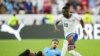 El delantero de Estados Unidos, Folarin Balogun (20), es derribado por el defensor uruguayo Ronald Araújo (4) durante la primera mitad de un partido de la Copa América en el Arrowhead Stadium.