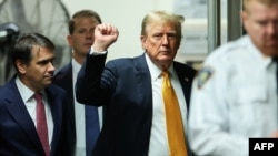 El expresidente estadounidense y candidato presidencial republicano Donald Trump levanta el puño cuando llega a su juicio penal en el Tribunal Penal de Manhattan en la ciudad de Nueva York, el 29 de mayo de 2024.