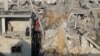 A Palestinian woman stands in a destroyed building as she inspects the site of Israeli strikes amid the ongoing conflict between Israel and Hamas in Khan Younis, Gaza, on Dec. 6, 2023.