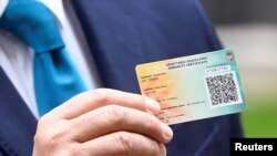 Прем’єр-міністр Угорщини Віктор Орбан демонструє угорський сертифікат імунізації проти COVID-19 під час візиту в Лондоні 28 травня 2021 р.