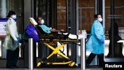 Trabajadores de salud transportan a un paciente usando una mascarilla en el NYU Langone Hospital en Manhattan, New York, durante el brote de coronavirus el 3 de mayo de 2020.