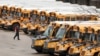 FILE - A worker passes public school buses parked at a depot in Manchester, New Hampshire, April 27, 2020.