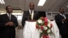 Malawi’s presidential aspirant in the May 20 tripartite elections and head of Malawi's United Democratic Front (UDF) party Atupele Muluzi (C) speaks next to his running mate Godfrey Chapola (L) and a Malawi Electoral Commission official (R) to present hi