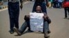An opposition protester holds a placard denouncing electoral commission officials, at a demonstration in downtown Nairobi, Kenya, Sept. 26, 2017. 
