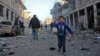 FILE - A Syrian boy runs while carrying bread following a reported airstrike by government forces, in the Syrian town of Binnish, on the outskirts of Idlib.