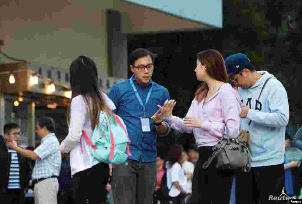 Personal electoral ayuda a un votante en un colegio electoral durante las elecciones locales del consejo de distrito en Hong Kong, China, el 24 de noviembre de 2019.