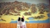 FILE - People point to a map on a wall in Mount Kumgang resort in Kumgang, Sept. 1, 2011. 