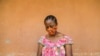 FILE - A woman checks her phone in Yaounde, Cameroon, April 23, 2020. 
