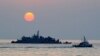 FILE - A South Korean goverment ship (R) sails by Navy MSB (Movement Sea Base) off the South Korea-controlled island of Yeonpyeong near the disputed waters of the Yellow Sea.
