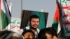 A person holds a placard with a picture of Yemen's Houthi movement leader, Abdul-Malik al-Houthi, as supporters rally to denounce airstrikes launched by the U.S. and Britain on Houthi targets, in Sanaa, Yemen, on Jan. 12, 2024.
