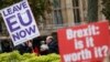 FILE - Pro- and anti-Brexit protesters hold placards as they vie for media attention near Parliament in London, Nov. 16, 2018. Britain's Prime Minister May still faces the threat of a no-confidence vote, after several Conservative Party lawmakers said they had wr