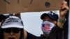 FILE - A supporter of President Donald Trump, right, wears a face mask as he participates in a "Freedom Rally" protest in support of lifting coronavirus restrictions in Florida, in South Beach in Miami, May 10, 2020.
