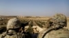 FILE - American troops look out toward the border with Turkey from a small outpost near the town of Manbij, Syria, Feb. 7, 2018. 