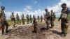FILE - Somali soldiers stand at a Somali military base, near the site of an attack by al-Shabab, in Lower Juba, June 13, 2018. The base was the target of another al-Shabab assault Monday.