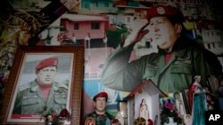 Retratos del fallecido presidente de Venezuela, Hugo Chávez, rodeados de imágenes religiosas dentro de una pequeña capilla, en el barrio 23 de Enero de Caracas, Venezuela.