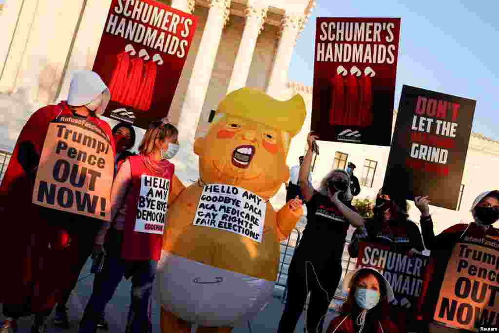 Activistas que se oponen a la elecci&#243;n de Barrett muestran pancartas que piden sacar al presidente Trump del poder e insultan al l&#237;der de la mayor&#237;a del Senado, Mitch McConnell, el lunes 26 de octubre de 2020.