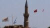FILE - Cyprus and Greek flags along with Turkish and Turkish Cypriot flags are seen near the U.N.-controlled buffer zone in Nicosia, Cyprus, July 6, 2017.