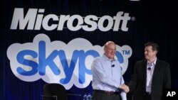El presidente de Microsoft, Steve Ballmer, izquierda saluda al presidente de Skype, Tony Bates durante el anuncio de la adquisición del sistema Skype por el gigante de los software, en mayo de 2011.
