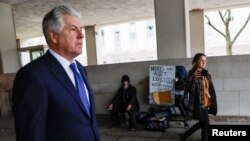 Una periodista intenta obtener declaraciones del abogado Evan Corcoran a su llegada a los tribunales, en Washington DC, para responder su implicación en presuntas irregularidades cometidas por su cliente Donald Trump.