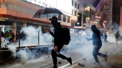 Manifestantes prodemocracia en Hong Kong huyen de gases lacrimógenos lanzados por la policía durante una marcha el Día de Año Nuevo el 1 de enero de 2020.