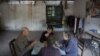 Patients and their relatives play cards in a dilapidated service building at Yangjia Hospital in Wuyi County, Zhejiang Province, China, Oct. 19, 2015. 
