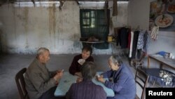 Patients and their relatives play cards in a dilapidated service building at Yangjia Hospital in Wuyi County, Zhejiang Province, China, Oct. 19, 2015. 
