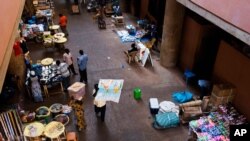 FILE - A man, center, carries a map with the African continent on it at a local market in the city of Ouagadougou, Burkina Faso, Nov. 4, 2014. The African continental free trade agreement, aiming to facilitate the movement of goods across the continent, went into effect Thursday.