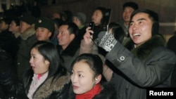 지난해 1월 평양 시민들이 새해맞이 불꽃축제에서 휴대전화로 사진을 찍고 있다.