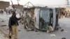A Pakistani police officer walks past a police vehicle targeted by a suicide bomber in Quetta, April 24, 2018.