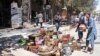 Afghan shopkeepers try to recover items from burning shops after a Taliban attack in Ghazni city, Afghanistan, Aug. 14, 2018.