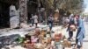 FILE - Afghan shopkeepers try to recover items from burning shops after a Taliban attack in Ghazni city, Afghanistan, Aug. 14, 2018. Afghan officials allege sanctuaries in Pakistan have enabled the Taliban to sustain and expand their insurgent activities. Islamabad calls these charges baseless.