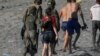 FILE -Seorang migran perempuan dikawal seorang tentara perempuan Spanyol saat dideportasi ke Maroko setelah dia melintasi perbatasan dengan berenang dari Maroko ke Spanyol, di pantai El Tarajal, di Ceuta, Spanyol, 19 Mei 2021.