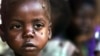 A starving child is covered with flies at the pediatric malnutrition ward at the Lilongwe Central Hospital, Malawi, April 24, 2002.