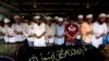 Muslims pray behind the coffins of victims of a fire during a funeral at Yaeway cemetery in Rangoon, April 2, 2013. 
