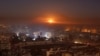 FILE - Smoke and flames rise after air strikes on rebel-controlled besieged area of Aleppo, as seen from a government-held side, in Syria, Dec. 11, 2016.