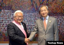 마이크 혼다(왼쪽) 전 미 연방하원의원이 26일 워싱턴 DC 주미 한국대사관저에서 안호영 대사로부터 수교훈장 광화장을 받은 뒤 악수하고 있다. (주미 한국대사관 제공)