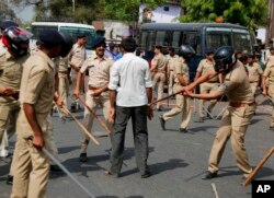 Indian policemen beat a lower caste Dalit protester during a nationwide strike in Ahmadabad, India, April 2, 2018.