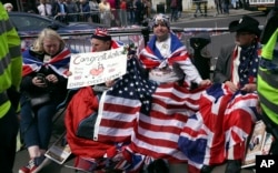 Royal fans John Loughry, second right, and Terry Hutt, second left, show off their placards outside Windsor Castle, in Windsor, England, May 16, 2018.