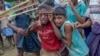 FILE - Rohingya Muslim boys, who crossed over from Myanmar into Bangladesh, cry as Bangladeshi men push them away during distribution of food aid near Balukhali refugee camp, Bangladesh, Sept 20, 2017.