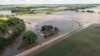 Un agente de la patrulla de caminos de Dakota del Sur observa un puente inundado tras días de fuertes lluvias en la zona, cerca de Lake Alvin, Dakota del Sur, el sábado 22 de junio de 2024.