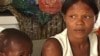 A quake victim and his mother wait for medical care