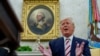 U.S. President Donald Trump answers questions from reporters sitting in front of a portrait of former U.S. President George Washington in the Oval Office of the White House in Washington, Aug. 20, 2019.