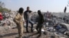 People look at a destroyed houses near the village of Barisha, in Idlib province, Syria, Oct. 27, 2019, after an operation by the U.S. military which targeted Abu Bakr al-Baghdadi. 