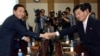 Kim Kiwoong, left, the head of South Korea's delegation shakes hands with his North Korean counterpart Park Chol Su, right, before their meeting