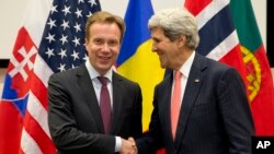 El secretario de Estado, John Kerry, saluda a su colega noruego, Borge Brende, durante la reunión de cancilleres de la OTAN en Bruselas.