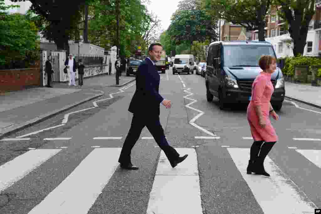 PM Inggris David Cameron bersama Menteri Kebudayaan Tessa Jowell berusaha meniru gaya sampul album &#39;the Beatles&#39; saat mengunjungi studio rekaman Abbey Road di London utara.&nbsp;