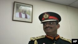 A portrait of Sri Lankan president Mahinda Rajapaksa is seen on the wall as Sri Lankan military chief General Sarath Fonseka looks on at the military headquarters after his retirement in Colombo, Sri Lanka, Monday, 16 Nov 2009